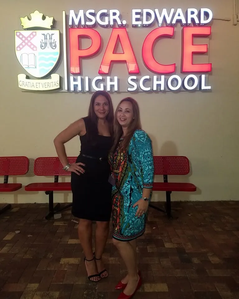 Two classmates in front of the lit-up Pace sign