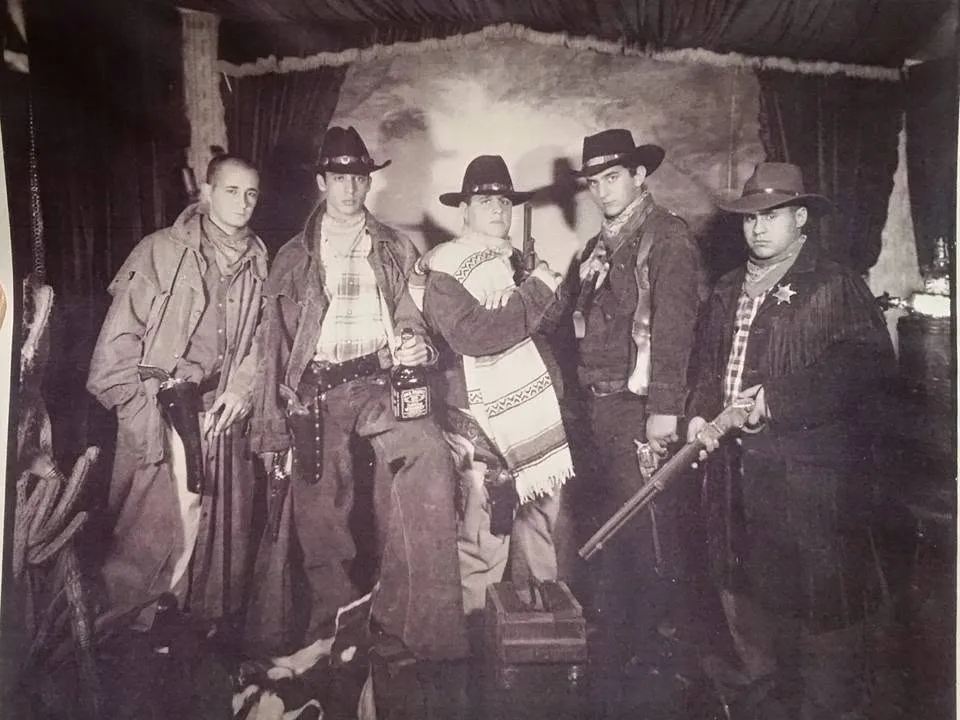 The cast of a school play in costume on stage